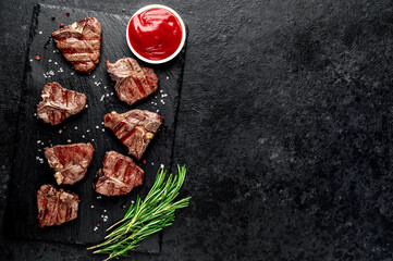 several mini Grilled beef T-bone steaks on stone background with copy space for your text