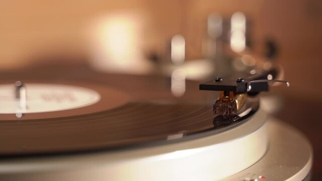 finger presses the button on the turntable and the neck of the turntable rises from the record