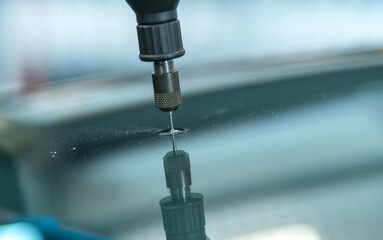 Glass drill is used to expand a hole in glass before the windshield is beeing repaired