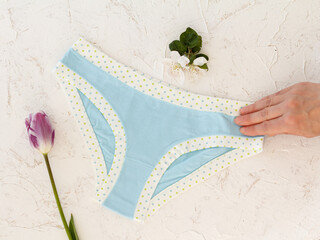 Woman's hand with beautiful panties on white background.