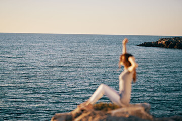 woman in a striped T-shirt raised her hands up near the sea in peas