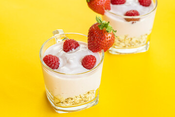 Delicious strawberry and raspberry yogurt on a yellow background