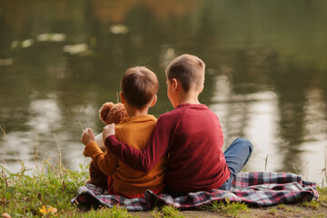 brothers are sitting on the lake