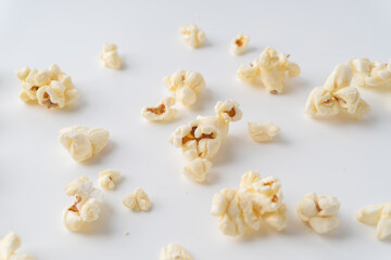 Many pieces of popcorn were scattered on white background.