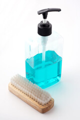 The cleaning solution in the pump bottle is placed with a scrubbing brush isolated on a white background, Cleaning equipment, Housework.