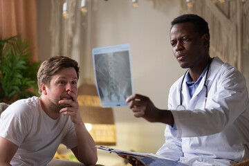 African doctor analyzing ultrasound results of his pacient.