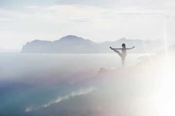 Woman practice yoga in an amazing landscape.