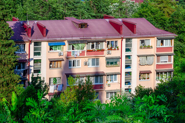 Beige facade with a red roof of an apartment building