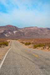 Fototapeta na wymiar Desert scenic road in Death Valley with mountain backdrop, California, USA. Amazing panorama of desert