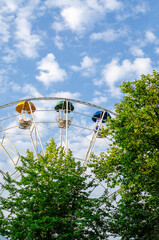 Ferris wheel with multi-colored booths. Vertical frame