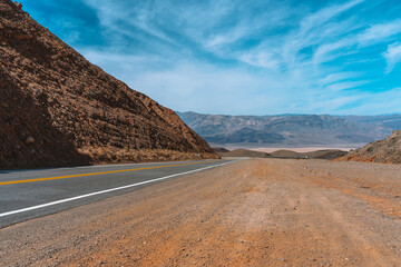 Desert scenic road in Death Valley with mountain backdrop, California, USA. Amazing panorama of desert