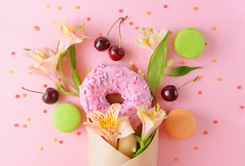 pink donat and fresh cherries, alstroemeria flowers, green and beige macaroons in a paper envelope...