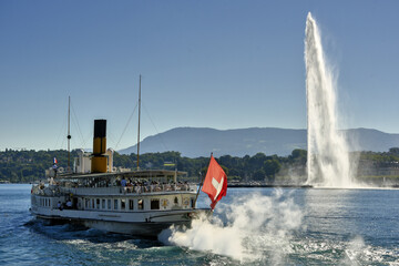 water jet and a vintage steamboat cruising on Lake Geneva, Geneva, Switzerland