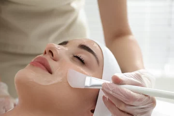 Papier Peint photo Salon de massage Young woman during face peeling procedure in salon