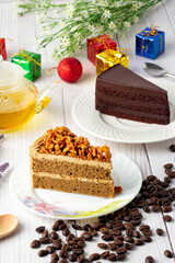 Almond Coffee Cake and chocolate fudge cake on a white plate, Beautiful decoration with gift boxes, coffee seed and flowers, Triangular cake,Holiday celebration, Beautiful decoration in the cake cafe.