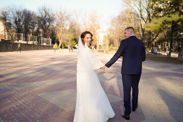 The groom holds the bride's hand and leads her. trust in the family. 