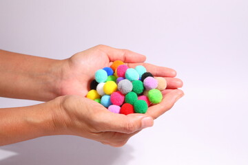 Colorful pompom in a wicker container on a white background