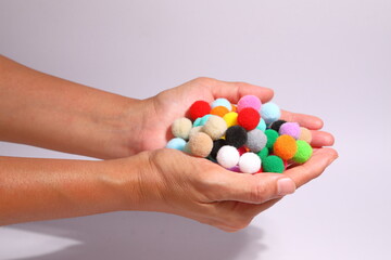 Colorful pompom in a wicker container on a white background