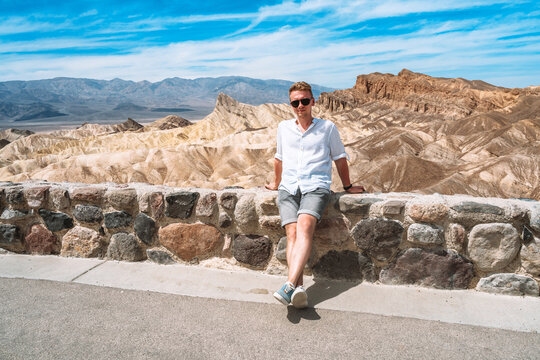 A young man in the desert in Death Valley with a view of Zabriskie Point, USA