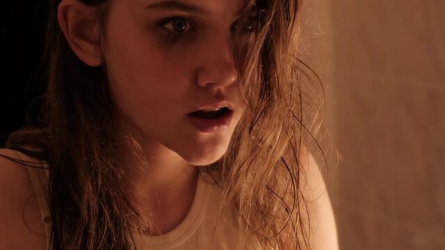 A girl suffering from a mental disorder. The girl is showing up taking drugs. A room with a blinking and broken light bulb.