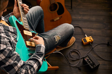 Young hipster man plays guitar.