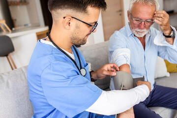 Male nurse measures blood pressure to senior man while being in a home visit.