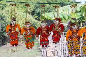 Colorful puppets in a tourist stall on the street market in Burma, Myanmar. Handmade dolls hanging...