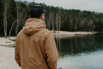 the guy looks into the distance at the lake