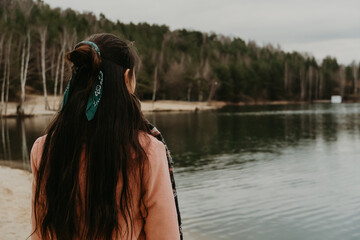 the girl looks into the distance at the lake