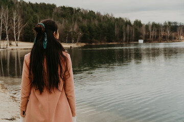 the girl looks into the distance at the lake