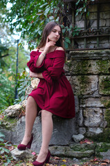 beautiful girl in a red dress on the street in the city