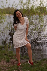 Young woman ib white dress near the river