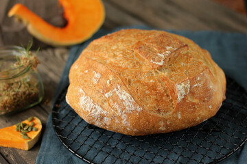 Pumpkin fresh bread on the table close-up. Fresh bread on the kitchen table. Healthy food and traditional bakery concept. Rustic style.