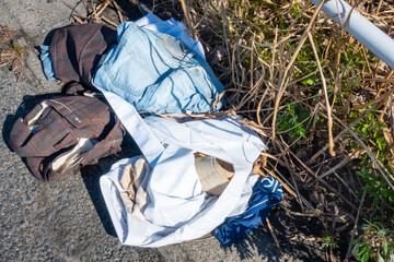 道に捨てられた服の写真。ゴミ問題のイメージ。