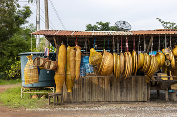 Lots of wickerwork hanging up for retail sale in the countryside.