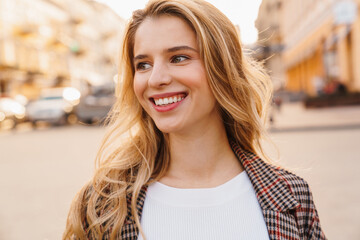 Close up of a smiling blonde young woman walking