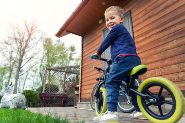 Little cute adorable caucasian toddler boy portrait having fun riding exercise balance run bike...