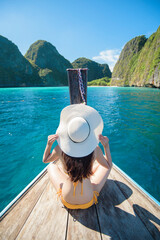 View of woman in swimsuit enjoying on thai traditional longtail Boat over beautiful mountain and...