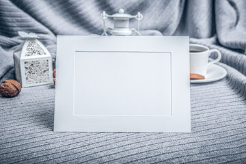 White frame, a beautiful plaid, a cup with coffee and cookies on a table with candles.