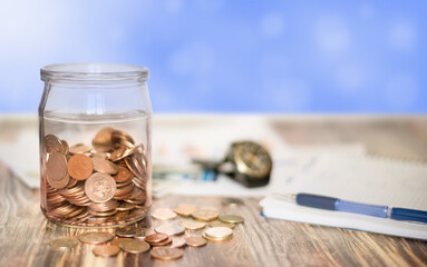 jar with coins stands on a wooden table. Russian rubles