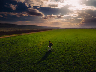 Portrait of a guy with a bike. Beautiful field out of town