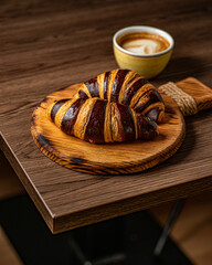 croissants sobre bandeja de madera y taza de café