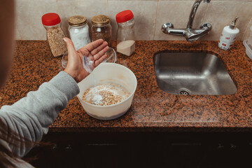woman preparing the mixture for some cookies. Adding a little flour to the mixture. Healthy and homemade food concept.