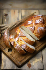 Fresh wheat bread sliced on a wooden board.