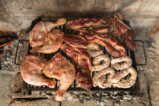 Top view of Argentinean asado a las brasas with short ribs, chicken quarters, and beef tripe.