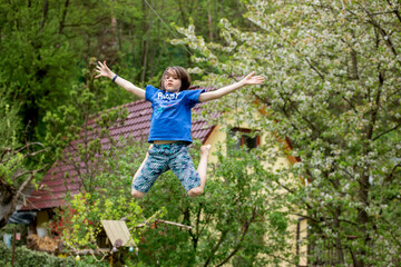 Naklejka na ściany i meble Child, jumping high on a trampoline