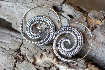 Silver metal decorative oriental spirale design earrings on natural neutral background - 433245671