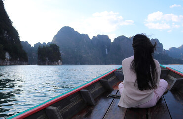 Travel on boat, summer holidays. Rear view of young happy people enjoying, Beautiful nature at Cheow Lan lake trip.
