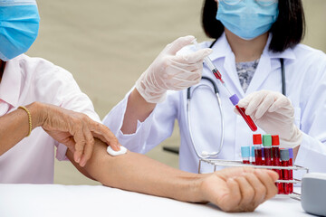 A doctor hands with a syringe and a sample of blood tube for analysis and test virus disease in the...