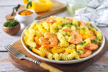 Spicy fusilli pasta with yellow pepper and red fried shrimps